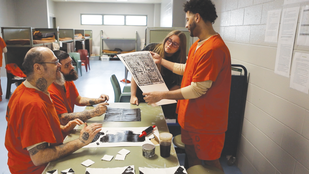 Ricky McNabb, William Baker, Erica Lewis, and David Wheatley inspect their cardstock collagraph print of the dorm’s entrance, titled “My Front Door.” Photo by Sergio Cabrera.